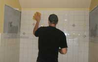 Andrew wiping the tile of a bath surround